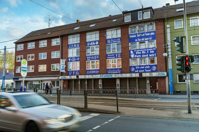 Ein Haus mit vielen blauen Schalke Plakaten an der Fassade