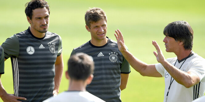 Bundestrainer Löw spricht mit Fußballern.