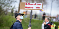 „Schluss mit dem Masken-Terror!“ steht auf dem Schild eines Teilnehmers einer Demonstration der Initiative „Querdenken“.