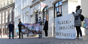 Protestierende stehen vor dem Konzerthaus Glocke in Bremen, wo das Landgericht coronabedingt tagt