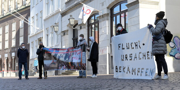 Protestierende stehen vor dem Konzerthaus Glocke in Bremen, wo das Landgericht coronabedingt tagt