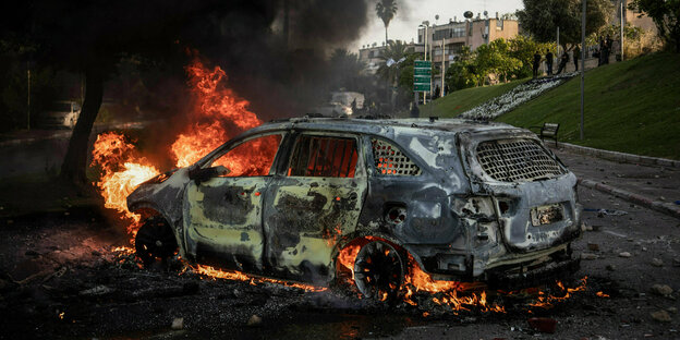 Ein brennendes Auto auf einer Straße in der Stadt Lod
