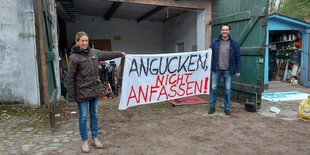 Zwei Menschen halten ein Banner mit der Aufschrift "Angucken nicht anfassen!"