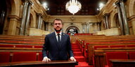 Der katalonische Politiker Pere Aragnones steht in einem Parlamentssaal mit roten Samtsitzen