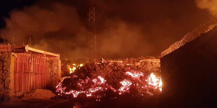 Brennend Lava zwischen Hütten in der Nacht