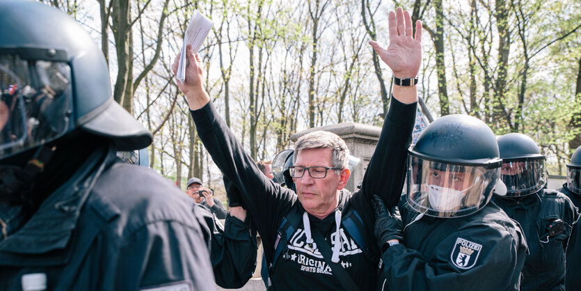 Michael Fritsch umgeben von Polizisten während einer Corona-Demo