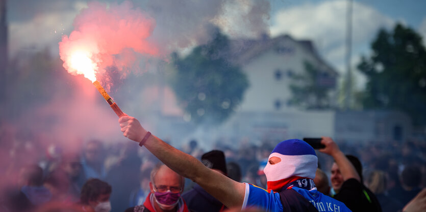 Ein Kiel-Fan zündet einen Bengalo