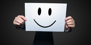 Lachendes Emoji-Gesicht auf einem Blatt Papier