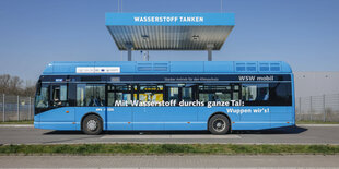 Ein blauer Buss vor einer Wasserstofftankstelle