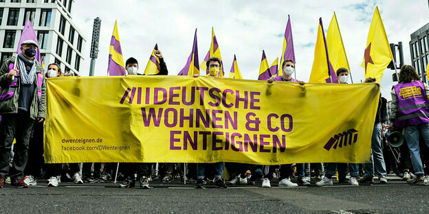 Demonstranten tragen das Transparent: Deutsche Wohnen und Co enteignen