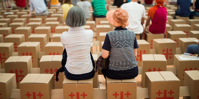 Zwei Frauen sitzen auf Pappkisten