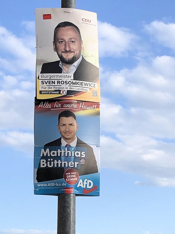 Zwei Wahlplakate von der CDU (oben) und der AFD hängen an einem Mast