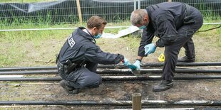 Polizeibeamte der Spurensicherung sichern nach einem Brand Spuren an einem Starkstromkabel in der Nähe der Tesla-Baustelle