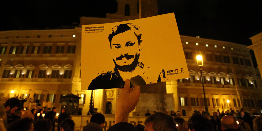 Ein Mann hält ein Bild, das Giulio Regeni zeigt in die Höhe