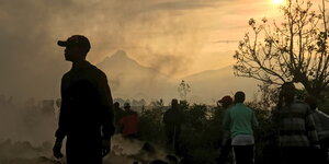 Menschen versammeln sich an einem Strom aus kaltem Lavagestein nach dem nächtlichen Ausbruch des Mount Nyiragongo in Goma