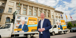 Das Bild zeigt CDU-Chef Kai Wegner vor Plakaten gegen Enteignung.