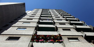 Eine graue Fassade, Blumen an einem Balkon