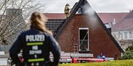 Einsatzkräfte der Feuerwehr arbeiten an einem durch Feuer beschädigten Haus im Stadtteil Mahndorf.