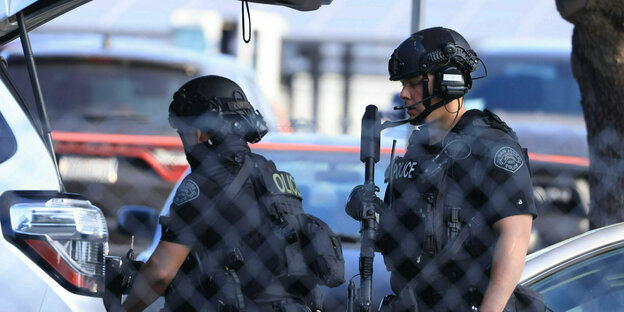 Zwei Polizisten mit Helmen und Waffen
