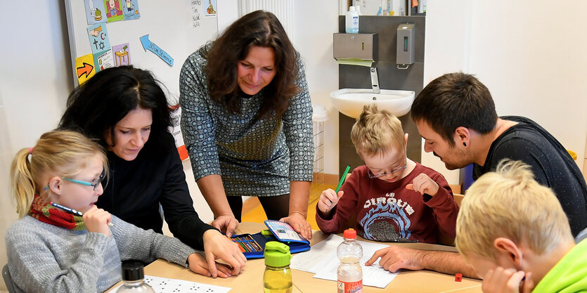 Lehrkräfte beschäftigen sich mit Kindern in einer inklusiven Schulklasse.