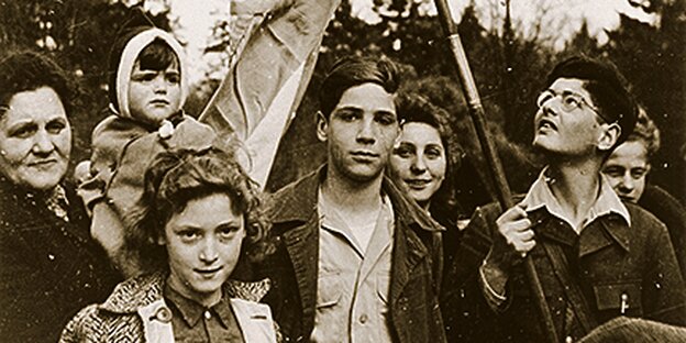 Junge Menschen stehen im April 1945 in Blankenese. Einer hält eine Fahne.