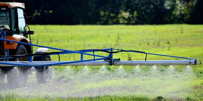 Traktor sprüht Pflanzenschutzmittel auf ein Feld