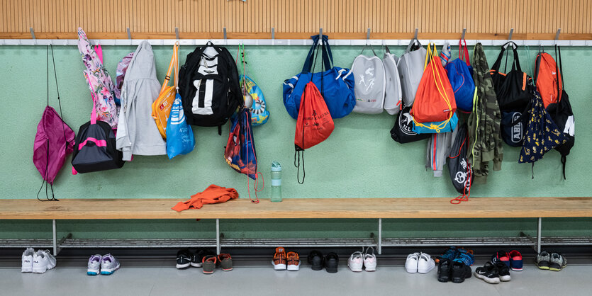 An der Garderobe in einer Schule hängen die Jacken der Schüler*innen