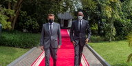 Frankreichs Präsident Macron und Ruandas Präsident Kagame auf einem roten Teppich.
