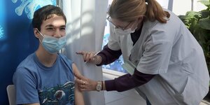 Ein Teenager in Tel Aviv erhält die Impfung gegen Covid-19
