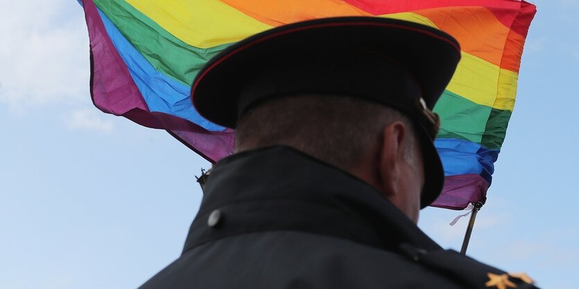 Ein POlizeibeamter vor Regenbogenfahne