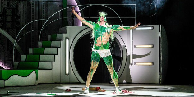 Kostümierter Held auf Theaterbühne mit grünem Schleim