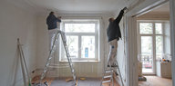 Zwei Maler streichen einen Raum