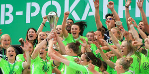 Die Spielerinnen des VfL Wolfburg feiern nach der Siegerehrung mit dem Pokal