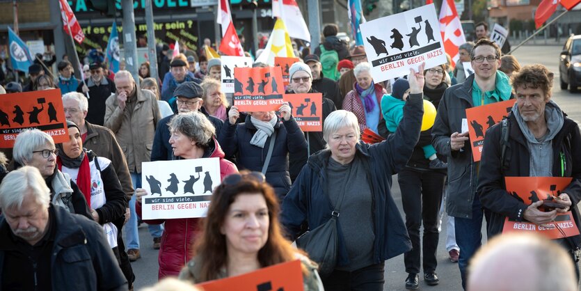 Menschen demonstrieren und halten Anti-Nazi-Schilder