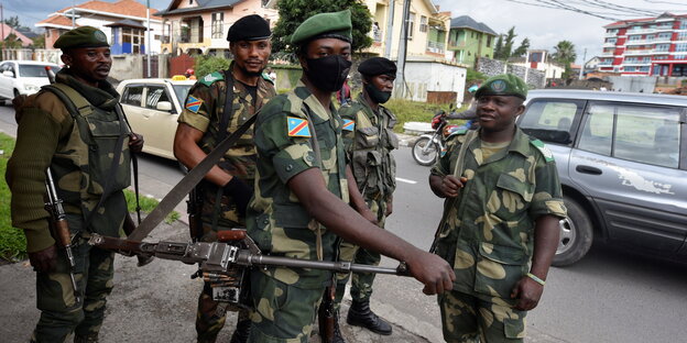 Kongolesische bewaffnete Soldaten stehen am Straßenrand