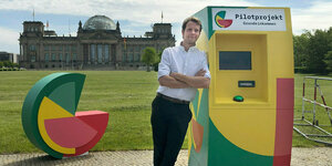 Michael Bohmeyer, Initiator des Vereins "Mein Grundeinkommen", steht an einem symbolischen Geldautomaten
