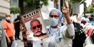 Eine Demonstrantin mit einem Foto von Brahim Ghali in der Hand- die Aufschrift lautet "Wanted"