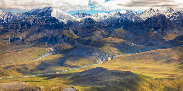 Landschaftsaufname des Arctic National Wildlife Refuge - grüne Täler durchzogen mit Flüssen und schneebedeckte Berge