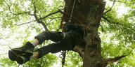 Ein Aktivist klettert hoch zu einem einem Baumhaus im Hambacher Forst