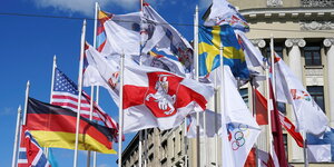 Weiß-rot-weiße alte Flagge von Belarus weht in Riga neben Flaggen anderer Nationen und Flaggen der internationalen Eishockey-Föderation