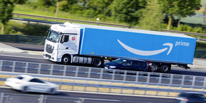 Ein blauer LKW mit Amazon Prime Logo auf der Autobahn