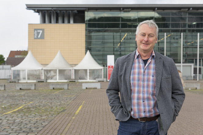 Mann vor Messehalle