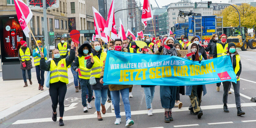 Kranken- und Pflegekräfte demonstrieren mit einem Banner von verdi mit der Aufschrift "Jetzt seid ihr dran!"