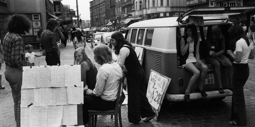 Unterschriftensammlung auf einer Strasse, einige Frauen sitzen in einem VW Bus, Weg mit §218 steht auf einem Schild