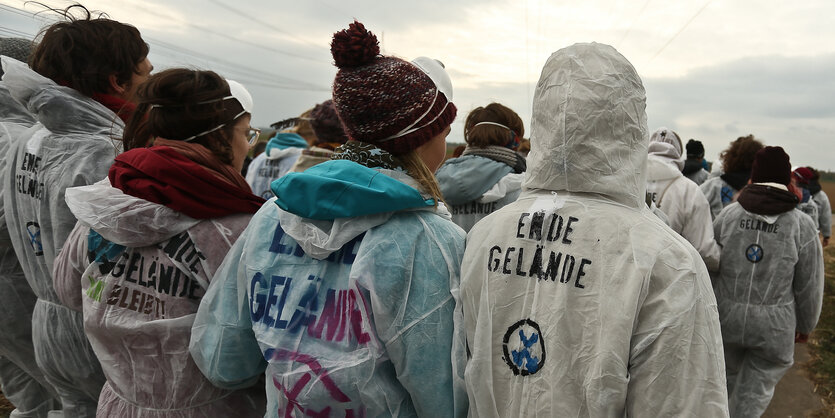 Menschen in weißen Anzügen auf einer Demo