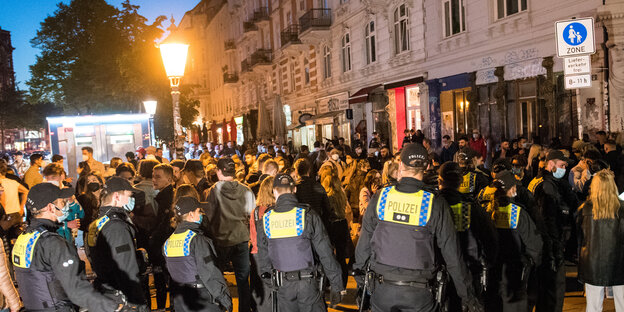 Eine Reihe Polizist:innen vor einer Menschenmenge