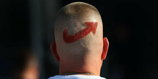 Ein AfD-Anhänger mit einem frisierten Logo der Partei auf dem Hinterkopf.