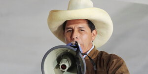 Portrait des peruanischen Präsidentschaftskandidaten Pedro Castilloe zu berühren, die von Anhängern des Kandidaten Pedro Castillo während einer Kundgebung in die Höhe gehalten wird