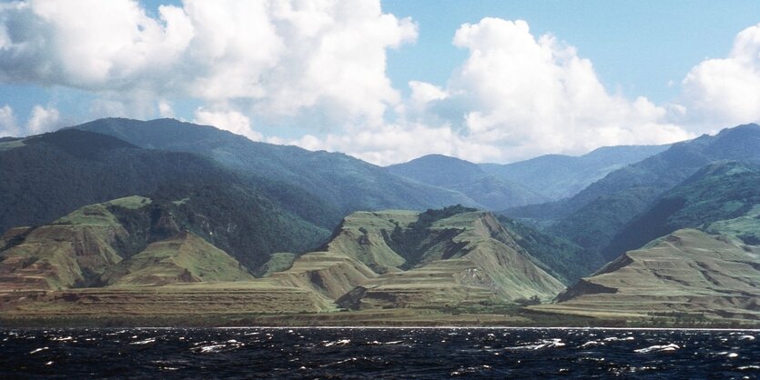 Blick vom Wasser aus auf grüne Berge