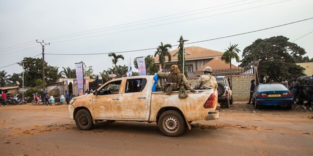 Ein Pick-up mit Sicherheitspersonal auf einer Straße in Bangui